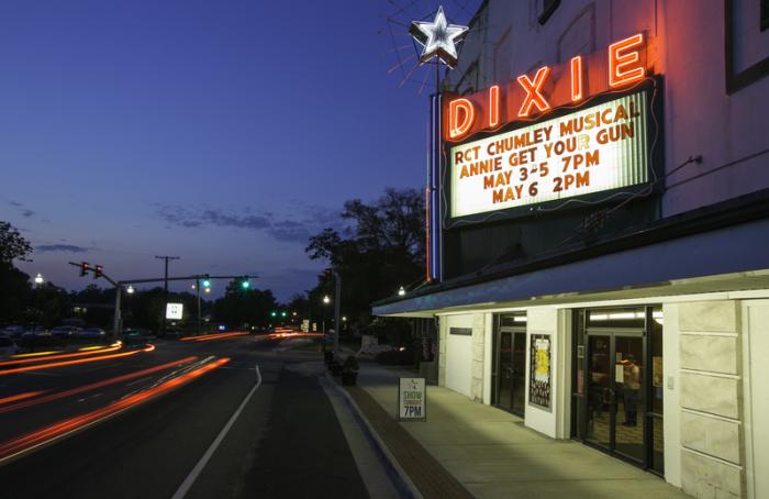 A classic theatre sign on a build next to a road at night time.
            The sign says in all caps RCT CHUMLEY MUSICAL and under that,  ANNE GET YOUR GUN.
            Then it has dates on the bottom of the sign saying May 3-5 7pm and May 6 2pm.